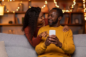 Loving black lady showing her husband nice online offer