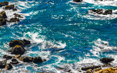 Beautiful rocks cliffs view waves at beach Puerto Escondido Mexico.