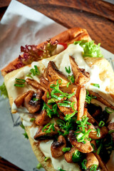 Breakfast sandwich with Omelette and mushrooms and white sauce. Concrete background. Hard light. Vegetarian food. Top view