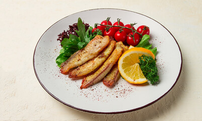 Fried Tilapia fish fillet, in spices, with cherry and salad, on a white plate, homemade, no people,