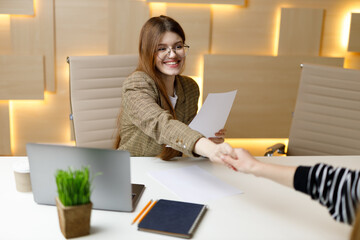 Handshake at a successful interview, a profitable business offer, business negotiations. Positive woman is a recruitment manager.