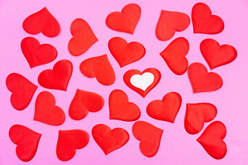 Bright red randomly scattered red hearts on a pink background. A declaration of love.