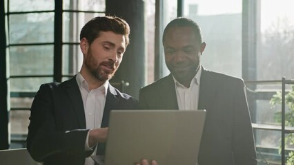 Caucasian professional male business expert man advice software pointing on laptop consulting African American client customer investor about online trading digital investment explain data at office