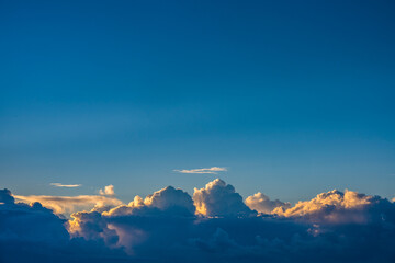Cumulus clouds on blue sky at sunrise
