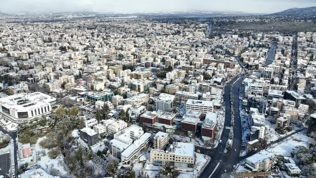 Aerial drone video of Kifisias avenue and urban area of Marousi covered in snow, Athens, Attica, Greece