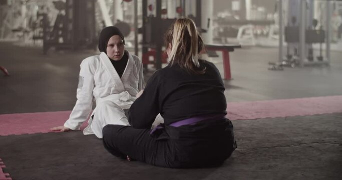 Female coach speaking with Muslim wrestler