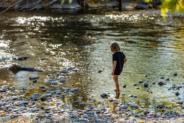 USA, Idaho, Bellevue, Girl (6-7) exploring river shallows in summer