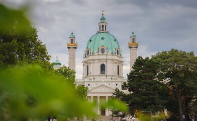 Fototapeta na wymiar Catholic church located in the southern part of Karlsplatz, Vienna. One of the symbols of the city. The Karlskirche is a prime example of the original Austrian Baroque style. view across park