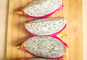 exotic dragon fruit of pink color, cut in half, on a wooden board. Weight loss, proper nutrition,...