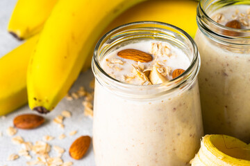 Almond banana smoothie with oat flakes in glass. Close up image.