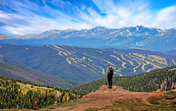 Hiker in Colorado above 12,000 feet on the West Ridge Trail near Loveland Pass with ski runs of Keystone in the background
