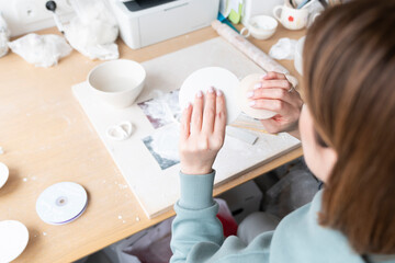 Close-up Image of female hands working with clay mug and making Ceramic Product. Professional Ceramic Artist makes  handcrafted products. Small business and hobby concept