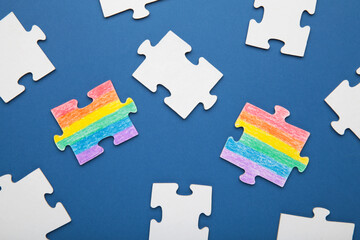 Concept LGBT as a part of society - two puzzle with the coloring of the flag of sexual minorities on dark blue background