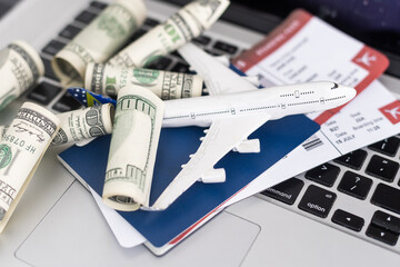Composition with laptop, toy plane, money and passport on map. Travel agency and ticket booking concept.