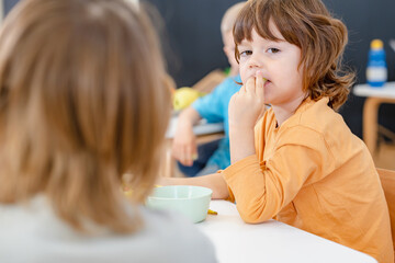 Children eating a fruit snack in a kindergarten 