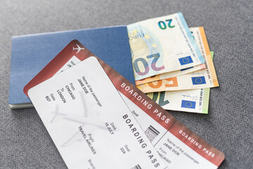 Two blue passports, green boarding pass, flight tickets gray background close up top view, airplane travel, passengers check in, customs control, border cross, holidays, vacation, tourism.