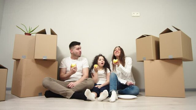 House move concept. Happy family sitting on the floor in new home