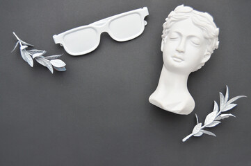 plaster head of venus, leaves, sunglasses Place for text. Wallpaper, black background. Place for...
