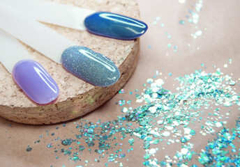 Samples of lacquer in blue shades and sequins on a natural monochrome background.