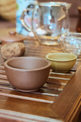 Naklejka na ściany i meble Traditional chinese tea ceremony utensils on a tea tray. Chinese glass teapot and clay tea bowls. Tea brewing equipment