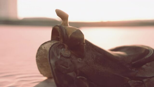 old horse saddle on the beach