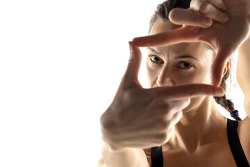 woman creating frame with her fingers on a white background