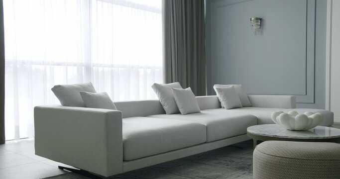 Modern contemporary Minimalist living room with white and gray furniture and round table. Luxury Modern House Interior With Corner Sofa. Minimalist Home Interior. Modern Furniture Design. Elegant Room