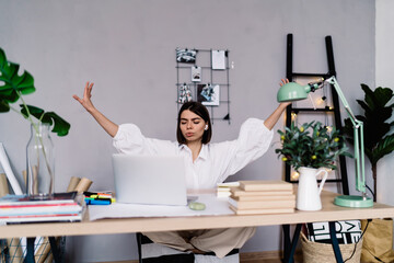 Content woman practicing breathing exercise at home office