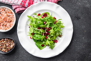 pomegranate salad green leaves, pomegranate seed,  lettuce mix healthy meal food snack on the table copy space food background rustic top view 