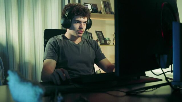 young gamer chatting with his friends with headset. Young man addicted to video games. Exotic hair.