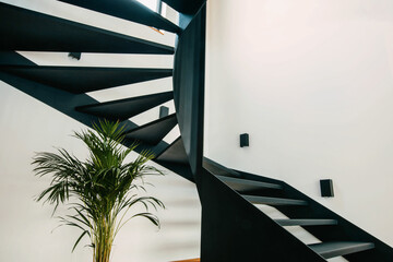 Black steel stairs in an industrial style in a modern house - obrazy, fototapety, plakaty