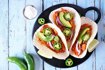 Jack fruit vegan tacos. Top view table scene on a blue wood background. Healthy eating, plant-based pulled pork meat substitute.