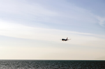 Fototapeta na wymiar Passenger plane flying low over the sea, landing