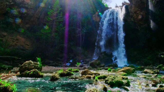 Beautiful large waterfall with sun beams in a real time. 