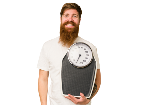 Adult redhead man with long beard holding a scale isolated cut out happy, smiling and cheerful.