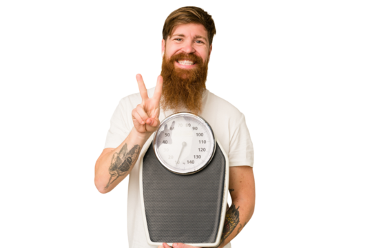 Adult redhead man with long beard holding a scale isolated cut out showing number two with fingers.