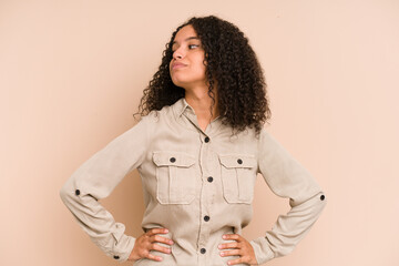 Young african american curly woman isolated dreaming of achieving goals and purposes