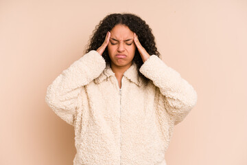 Young african american curly woman isolated touching temples and having headache.