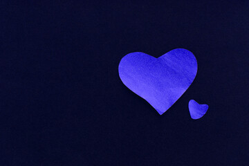Two blue sparkling heart on a dark blue background, made of paper, romantic and festive beautiful symbol, background. Paper textures, valentines day
