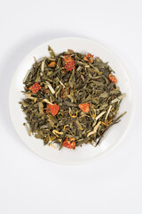 Green tea with aromatic additives. Top view on white background