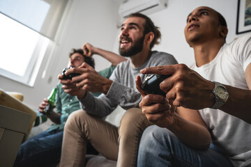 Group of best friends at home playing games on console, having fun and challenge each other to win.