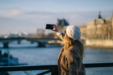 Young woman taking selfie on bridge during holidays