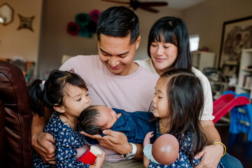 Happy smiling family welcoming newborn at home