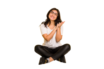 Young indian woman sitting on the floor cut out isolated feeling energetic and comfortable, rubbing hands confident.