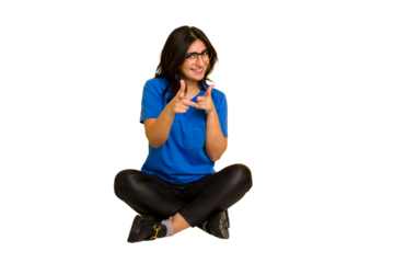 Young indian woman sitting on the floor cut out isolated pointing to front with fingers.