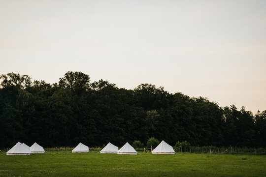 Bell tents on a field by sunset