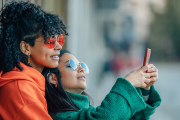 girl couple with phone making selfie photo on the street