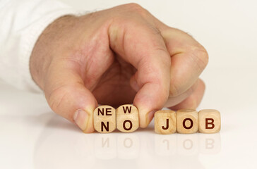 On the reflective surface in the hands of a man are cubes with the inscription - NEW JOB or NO JOB
