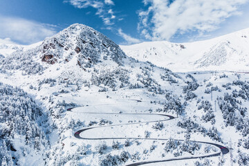 Vallter 2000 ski resort and snowy peak of Gra de Fajol mountain.Winter landscape with winding road,...