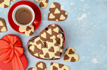 Chocolate vanilla heart cookies or biscuits in a red heart shaped box. Sweet gift for Valentine's Day. Top view. Copy space